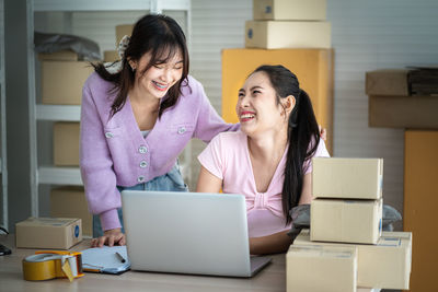 Young woman using phone while sitting in office