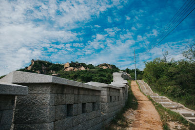 Footpath amidst buildings against sky