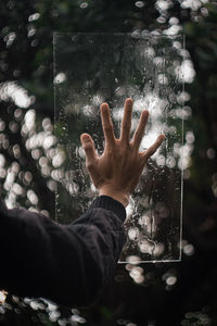 Midsection of person touching water