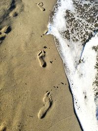 High angle view of footprints on sand at beach