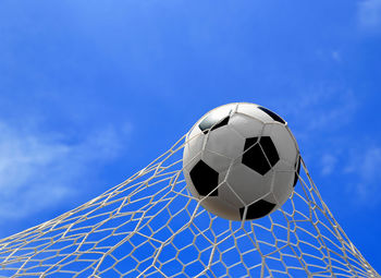 Soccer ball hitting in goal post against blue sky