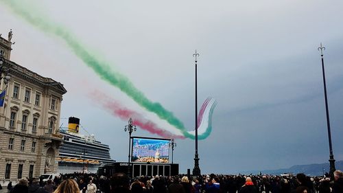 Crowd at concert against sky in city