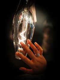 Close-up of hand holding illuminated light bulb