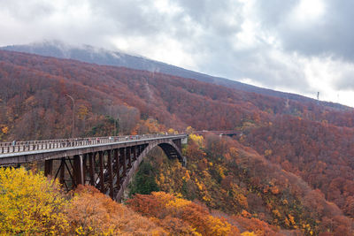 Arch bridge over landscape against sky during autumn