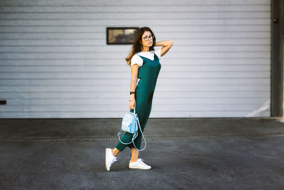 Full length of woman standing against wall