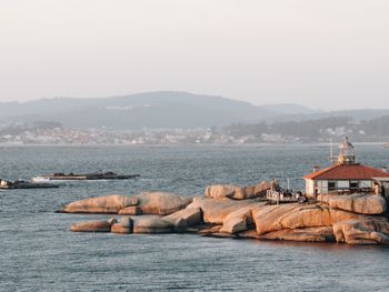 Scenic view of sea by city against sky