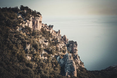 Rock formation in sea against sky