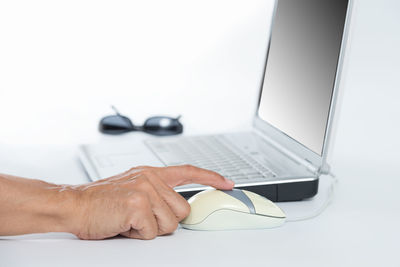 Close-up of man using laptop on table