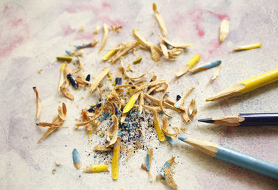 High angle view of colored pencils and shavings on table