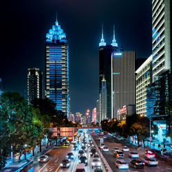 View of city street and buildings at night