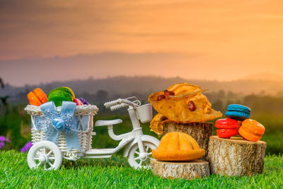 Multi colored toys on table at field against sky during sunset