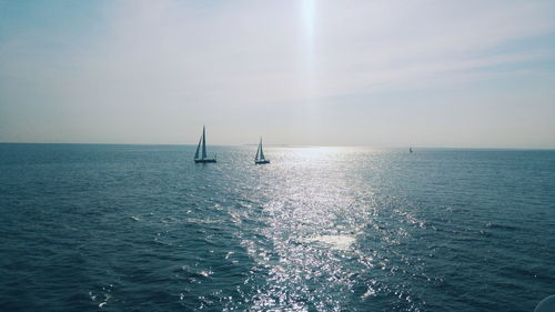 Sailboat sailing on sea against sky
