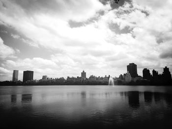 River in city against cloudy sky