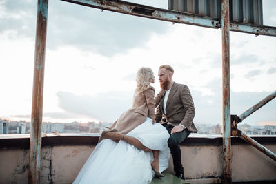 Rear view of couple standing against sky