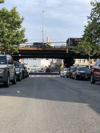 Cars on road in city against sky