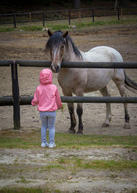 Full length of girl standing in a fence