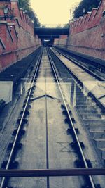 Railway tracks at railroad station against sky