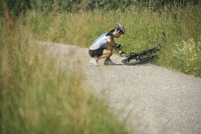 Side view of woman repairing bicycle