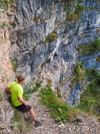 Boy at steel chain in rocky wall, via ferrata style. path name in italy sentieri attrezzato donini