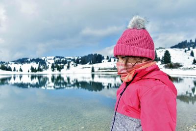 Portrait of person standing by lake during winter