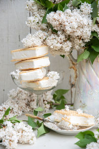 Spring still life with bouquet of white lilacs,stack of waffle ice cream in bowl,vintage ceramic
