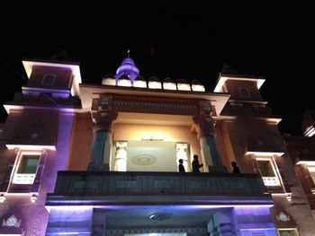 Low angle view of illuminated building against sky at night