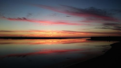 Scenic view of lake against orange sky