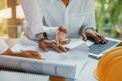 Midsection of man using laptop on table