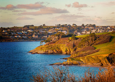 Aerial view of townscape by sea against sky