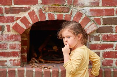 Pretty young girl playing with a brick stove at a farming exhibition