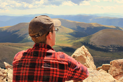 Rear view of man against mountains and cloudy sky at mount bierstadt