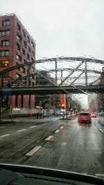 Cars on road in city against sky