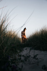 Side view of woman sitting on field