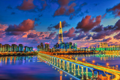 Illuminated buildings in city at sunset