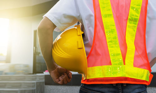 Midsection of man working with umbrella