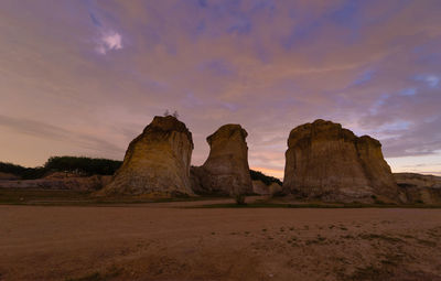 Rock formations on landscape against sky during sunset