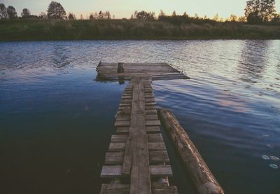 Wooden structure in lake against sky