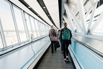 Rear view of people walking on bridge