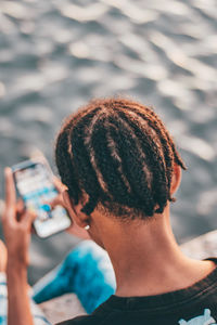 High angle view of young man using mobile phone at beach