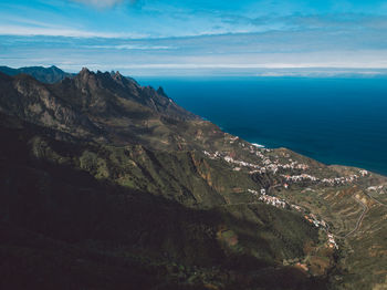 Scenic view of sea and mountains against sky