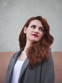 Close-up of young woman standing against wall