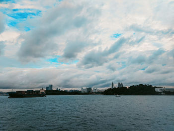 Scenic view of sea by buildings against sky