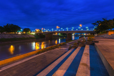 Illuminated bridge over river against sky at night