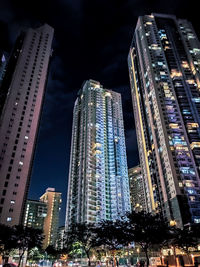 Low angle view of illuminated buildings against sky at night