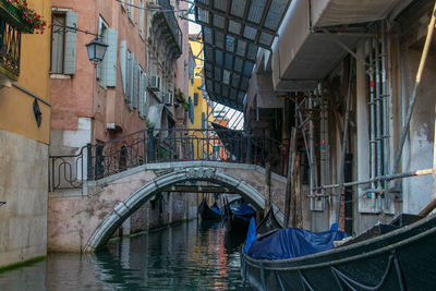 Arch bridge over canal amidst buildings in city