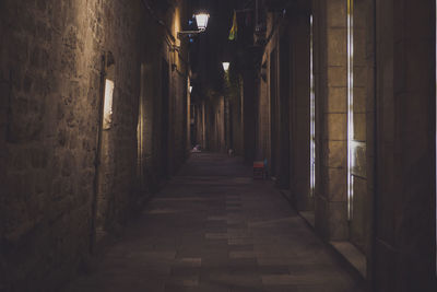 Alley amidst illuminated buildings at night