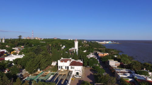 High angle view of buildings by sea against clear sky