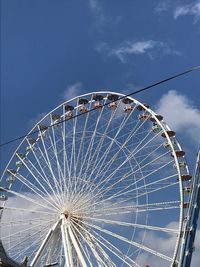 Low angle view of ferris wheel against blue sky