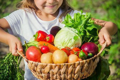 Midsection of woman holding vegetables