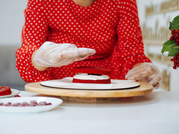 Midsection of man preparing cake on table